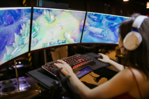 Une jeune femme jouant à un jeu vidéo sur un ordinateur avec un setup de gaming moderne.